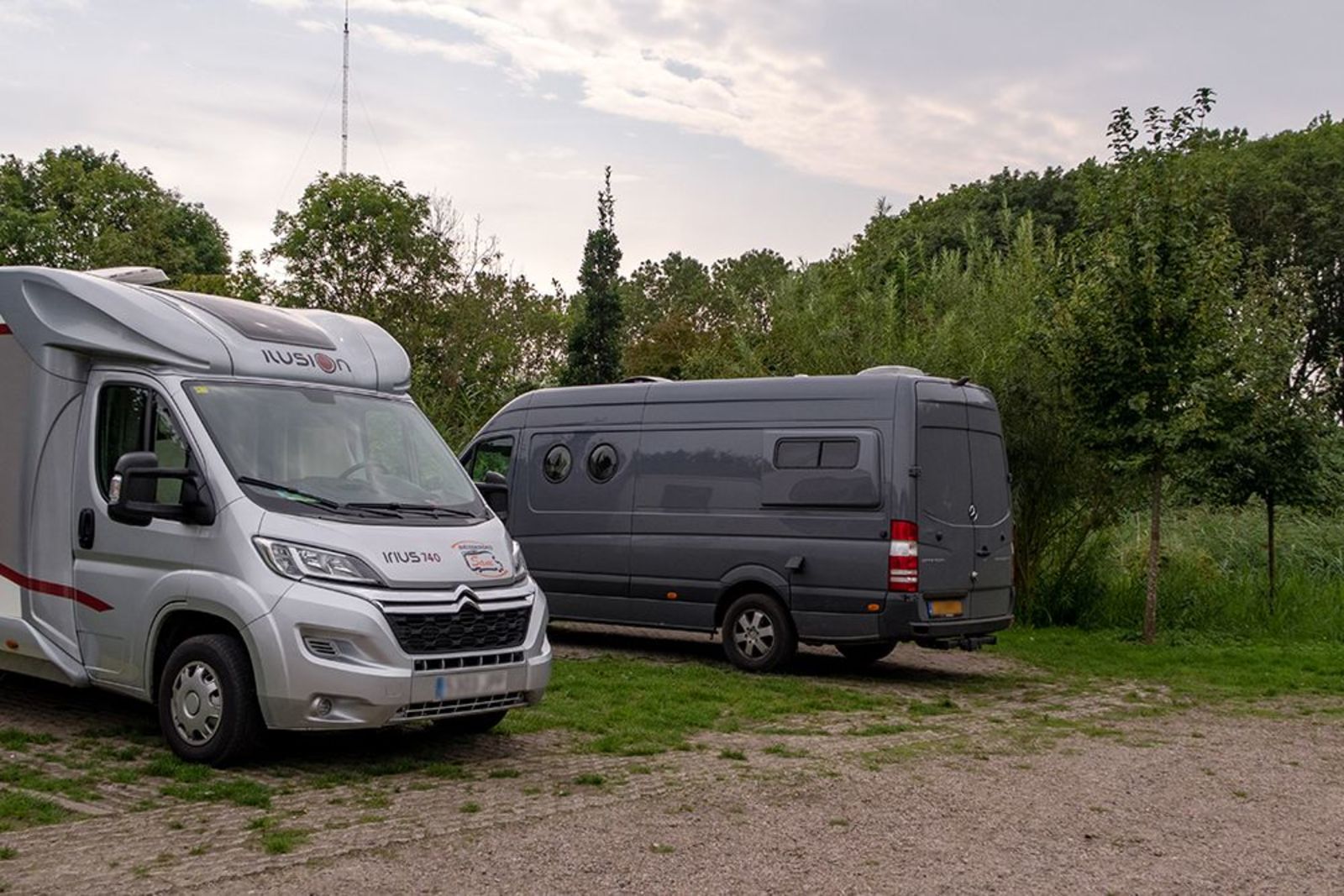 Two motorhome/camper pitches side by side on a corner